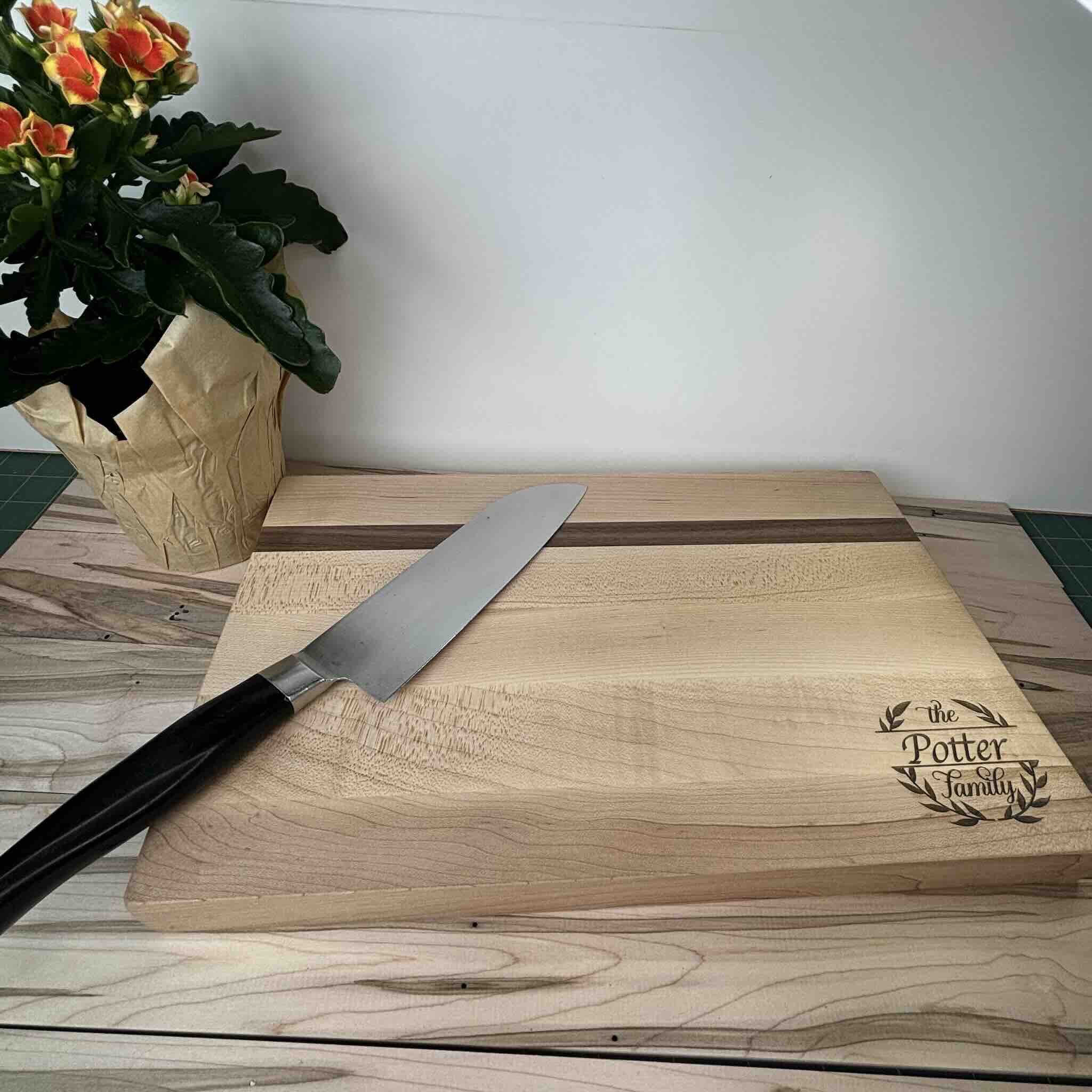 Custom engraved wooden cutting board with knife and flower pot
