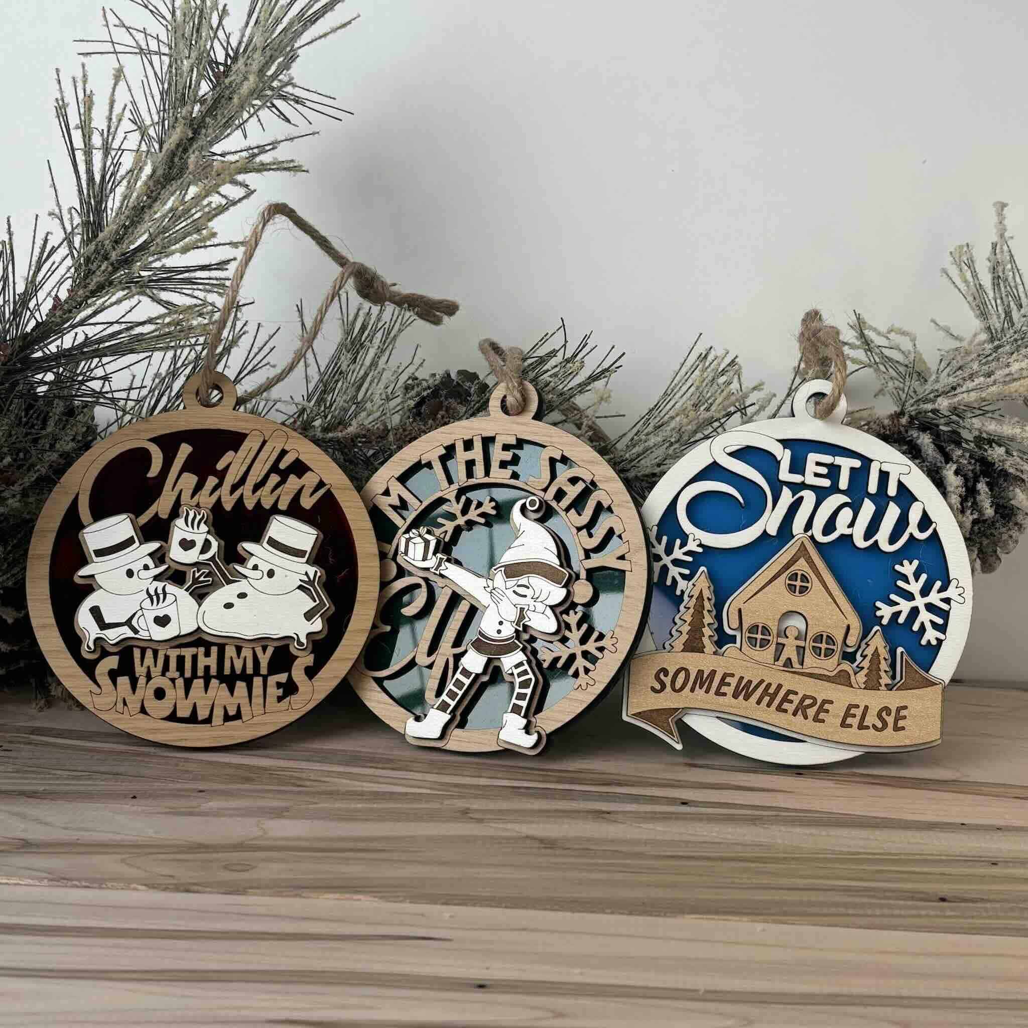 A collection of wooden Christmas ornaments featuring whimsical winter scenes and playful messages.