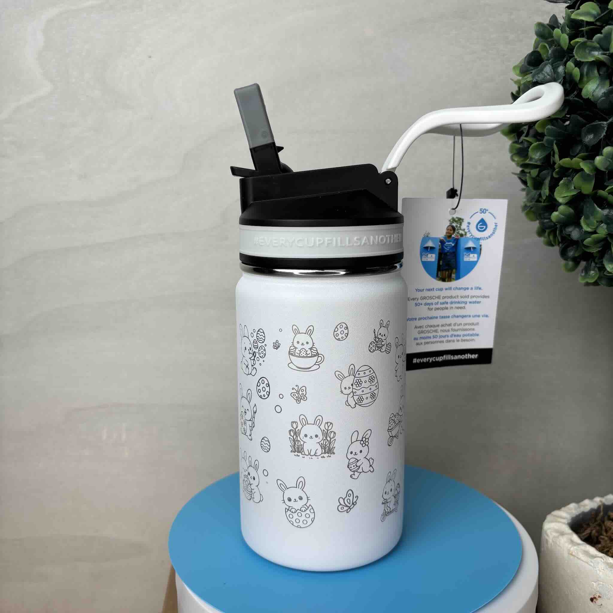 White water bottle with cute animal illustrations on a blue table
