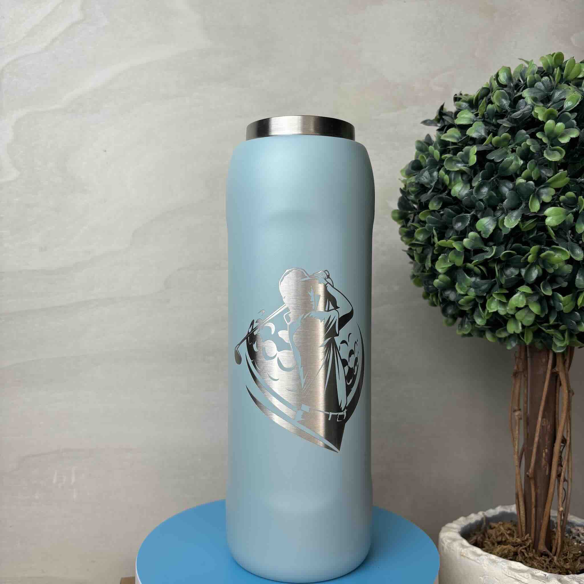 Modern blue thermos adorned with an art deco pattern next to a trimmed potted plant
