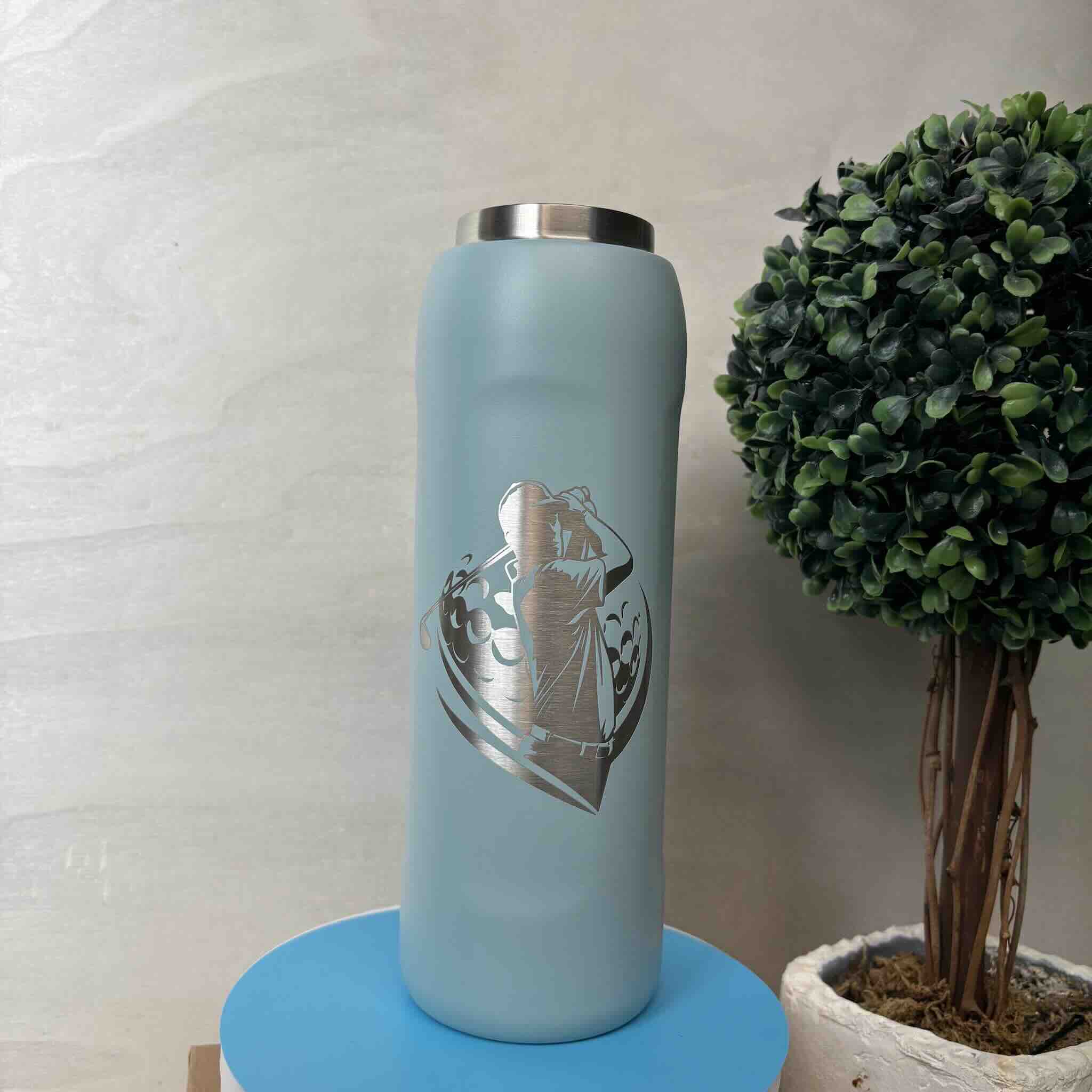 Stylish grey water bottle with a heart design beside a green plant